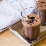 Ingredientes 100 g de chocolate semi amargo troceado 40 g de aceite de girasol 440 g de leche fría 1 yema de huevo 80 g de azúcar 50 g de harina 0000 30 g de cacao puro en polvo 1 pellizco de sal 250 g de helado de vainilla Preparación Poner en el vaso el chocolate y rallar 8 seg/vel 8. Con ayuda de la espátula bajar el chocolate hacia el fondo del vaso. Añadir el aceite y programar 3 min/50ºC/vel 1. Incorporar 90 g de leche, la yema, el azúcar, la harina, el cacao en polvo y la sal y mezclar 30 seg/vel 6. Repartir el contenido del vaso en 2 tazones (tipo mug). Poner los tazones en el microondas entre 1-3 minutos a máxima potencia (el tiempo dependerá del microondas). Dejar enfriar los brownies. Lavar el vaso. Reservar 1 cucharada del brownie. Poner en el vaso el resto de los brownies, 350 g de leche y el helado de vainilla y triturar 1 min 30 seg/vel 10. Servir en 4 vasos espolvoreados con el brownie reservado desmenuzado.