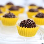 Ingredientes 370 g de leche condensada 30 g de cacao puro en polvo 40 g de manteca (y algo más para engrasar el molde) 150 g de virutas de chocolate Preparación Poner la leche condensada, el cacao y 40 g de manteca en el vaso y programar 10 min/100ºC/vel 3. En lugar del cubilete, colocar el cestillo encima de la tapa apoyado sobre sus cuatro patitas. Programar 26 min/Varoma/vel. 2, con el cestillo situado sobre la tapa en vez del cubilete. Verter el contenido del vaso en un recipiente engrasado con manteca y dejar enfriar. Con las manos engrasadas con manteca, formar bolas pequeñas con la mezcla y rebosarlas en las virutas de chocolate y ponerlas en pirotines para trufas. Reservar en la heladera.
